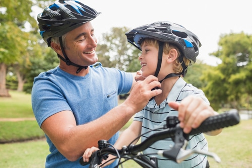 dad-helping-boy-on-bike-with-helmet